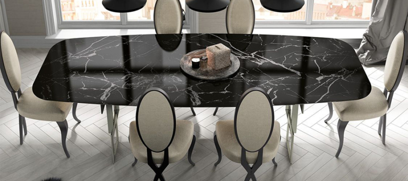Top view of black marble table with silver legs and chairs in dining room.
