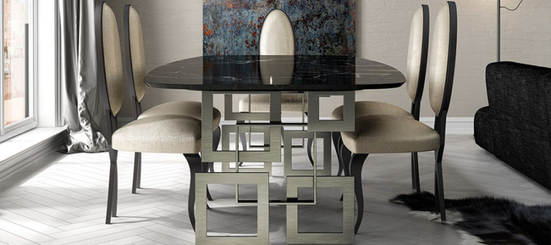 Side view of black marble table with silver legs and chairs in dining room.