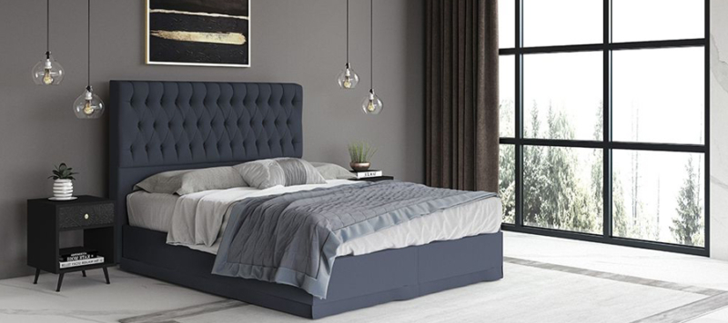 Blue fabric bed in bedroom.