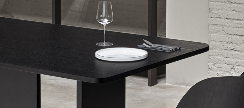 Diner is served on a black teulat dining table.